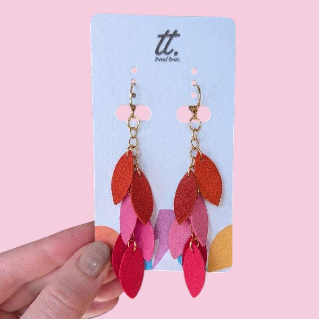 a hand holding a pair of earrings