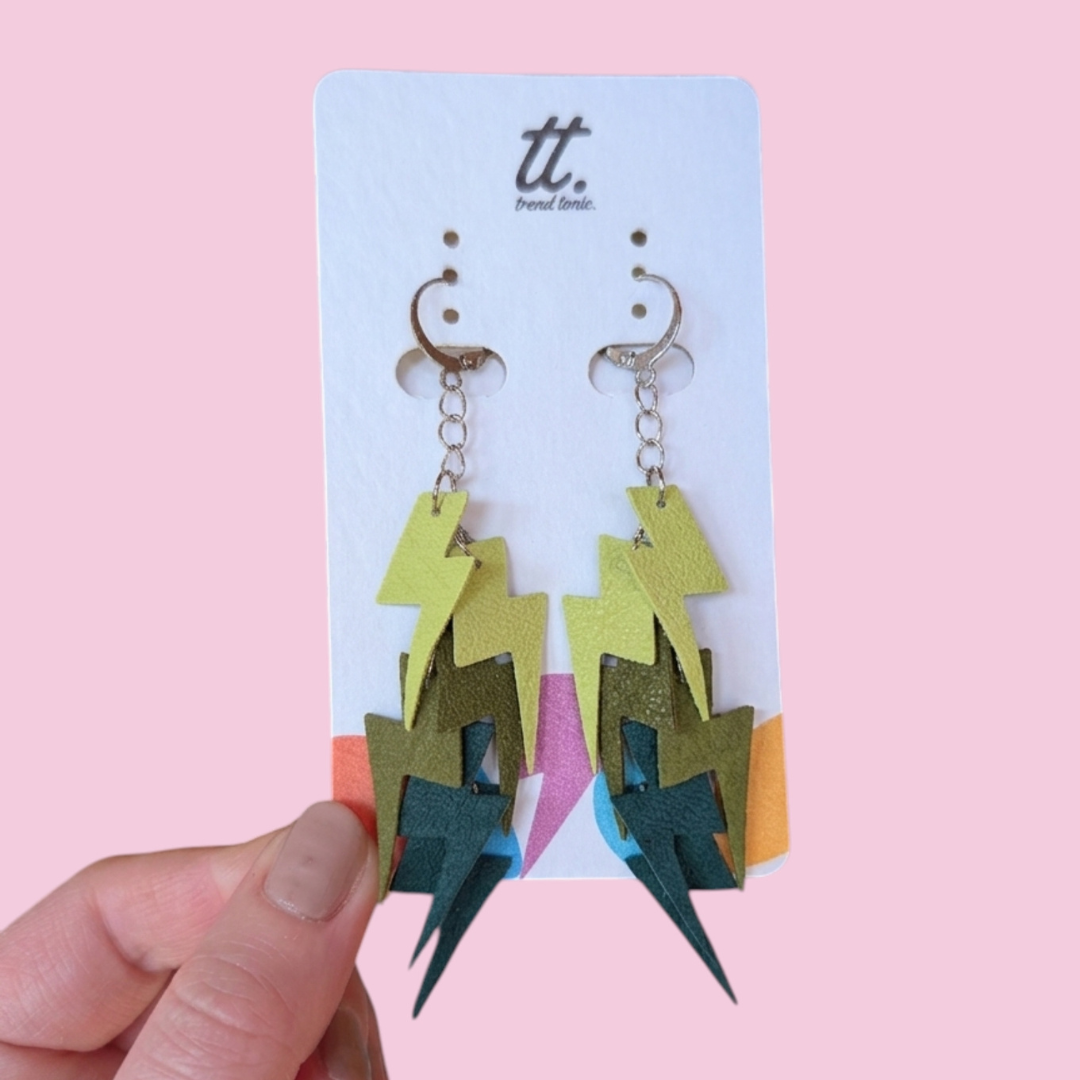 a hand holding a pair of earrings