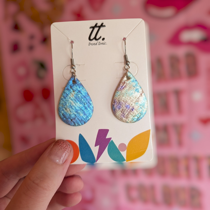 a hand holding a pair of earrings