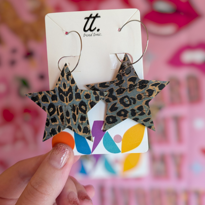 a hand holding a pair of earrings