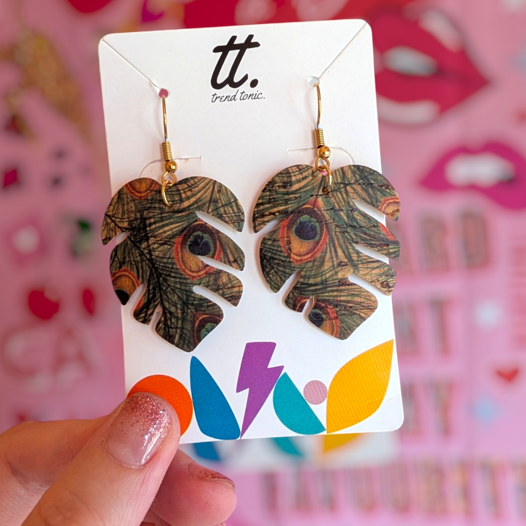 a hand holding a pair of earrings