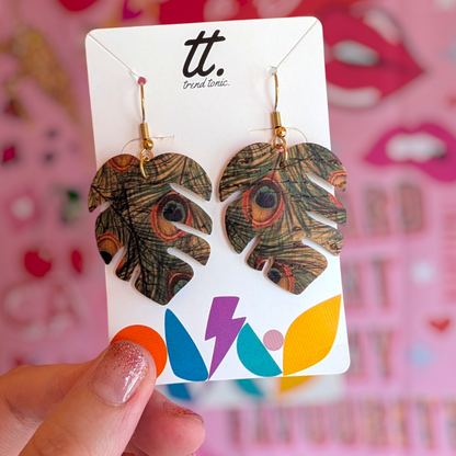 a hand holding a pair of earrings