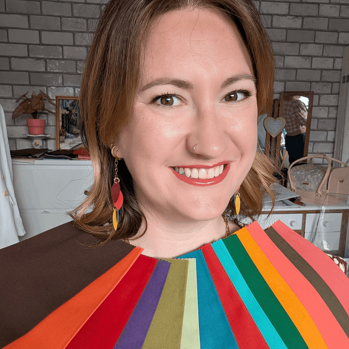 a woman smiling with a fan of colorful paper