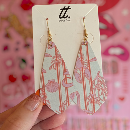 a hand holding a pair of earrings