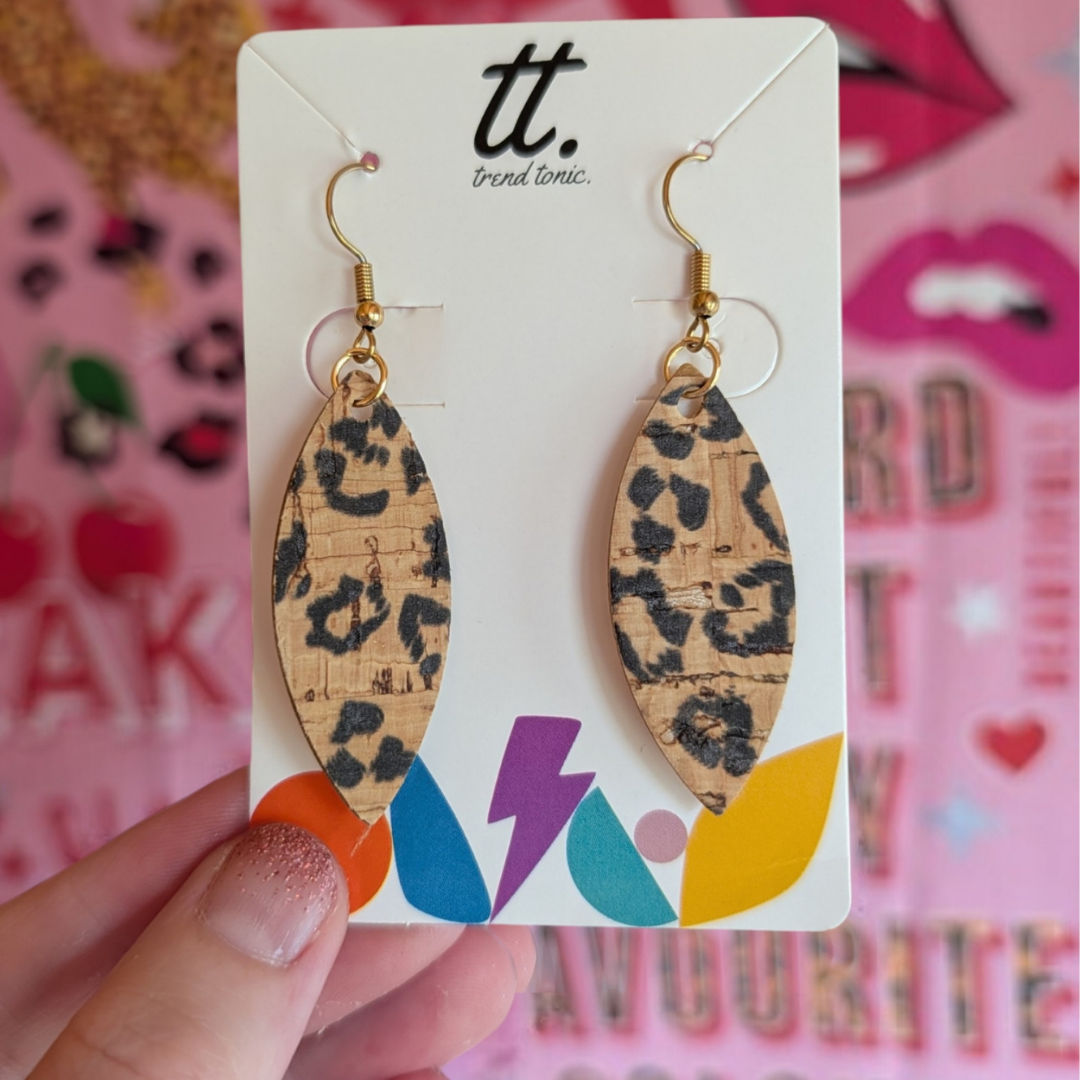 a hand holding a pair of earrings