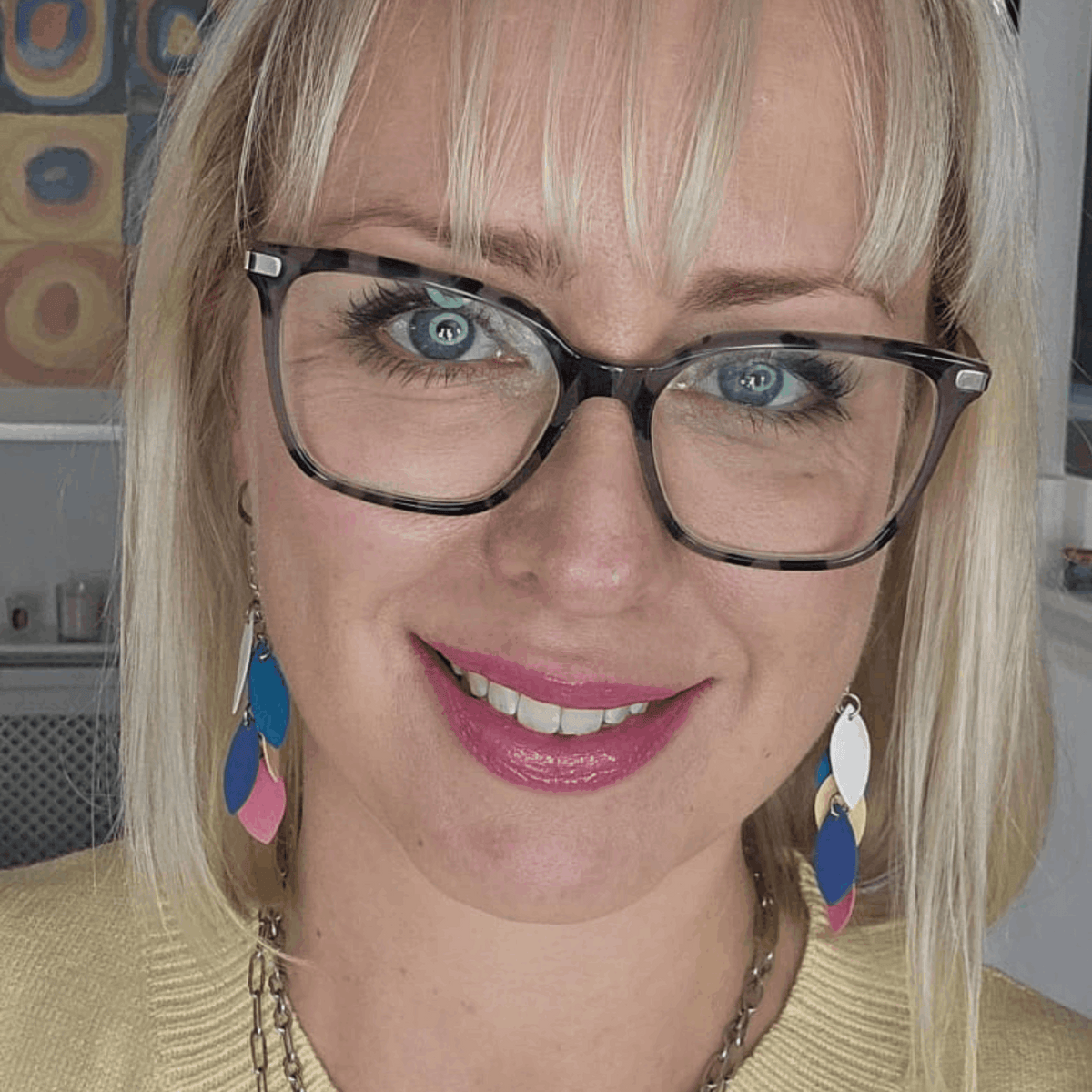 a woman wearing glasses and a yellow sweater