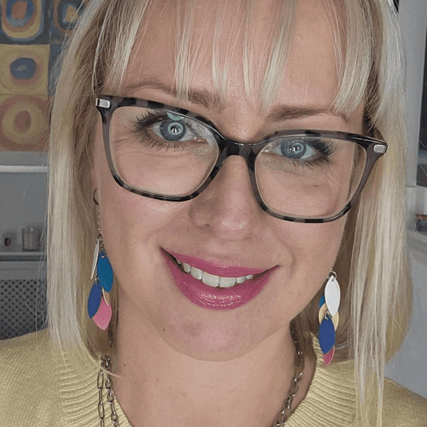 a woman wearing glasses and a yellow sweater