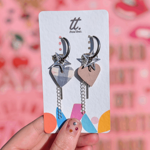 a hand holding a pair of earrings