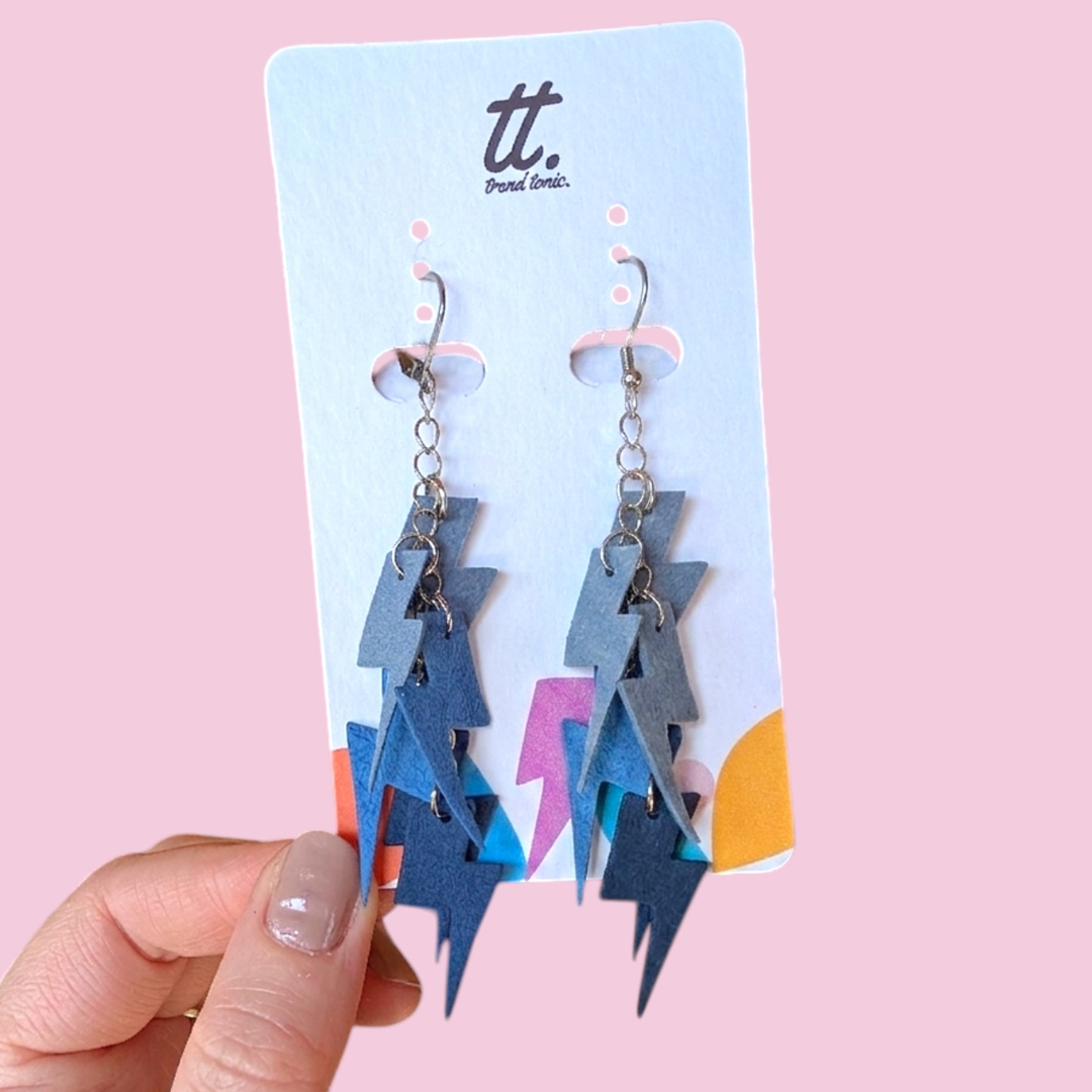 a hand holding a pair of earrings