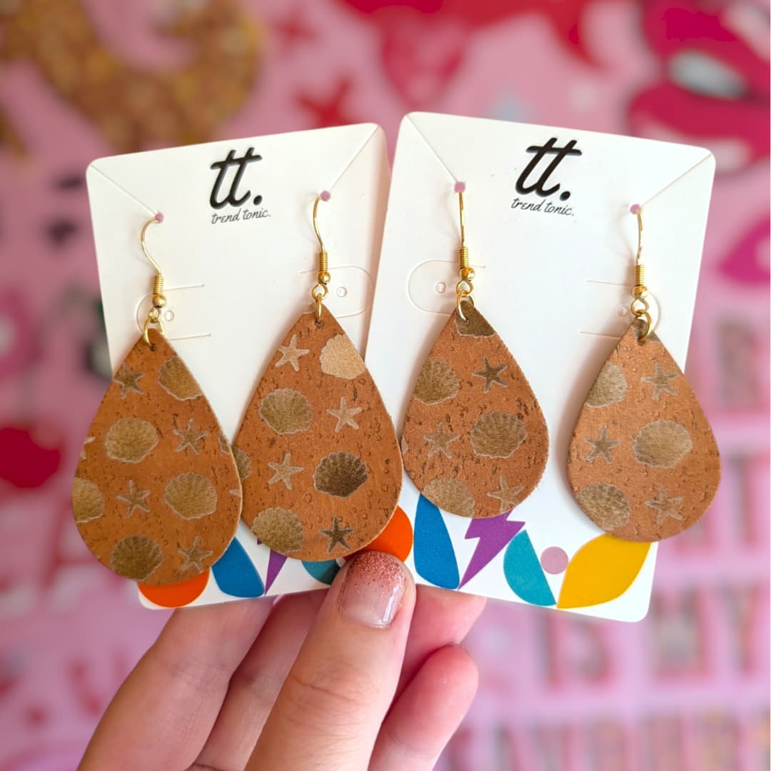 a hand holding a pair of earrings
