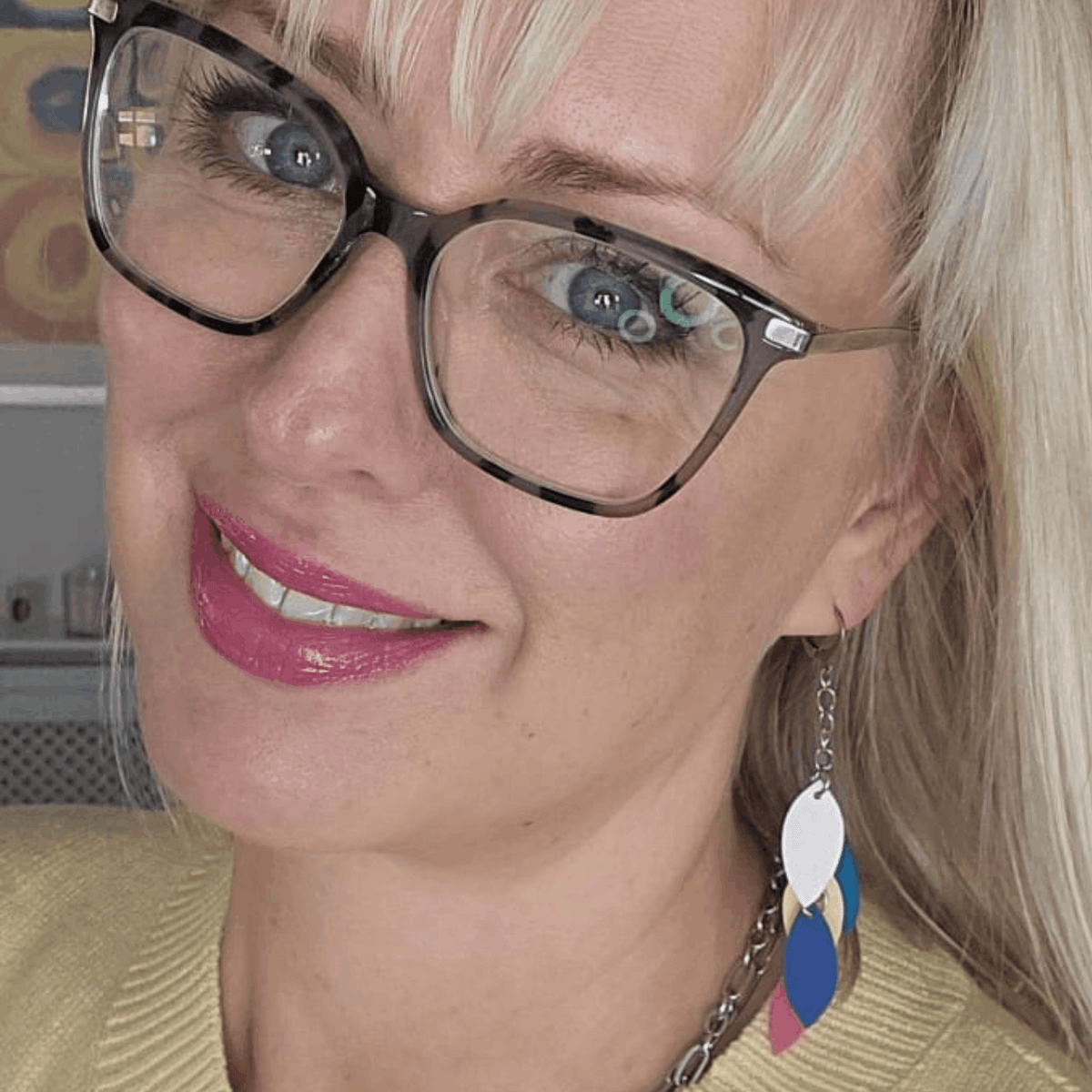 a woman wearing glasses and smiling