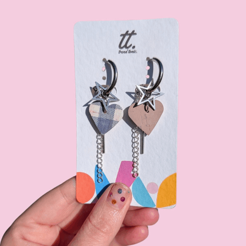 a hand holding a pair of earrings