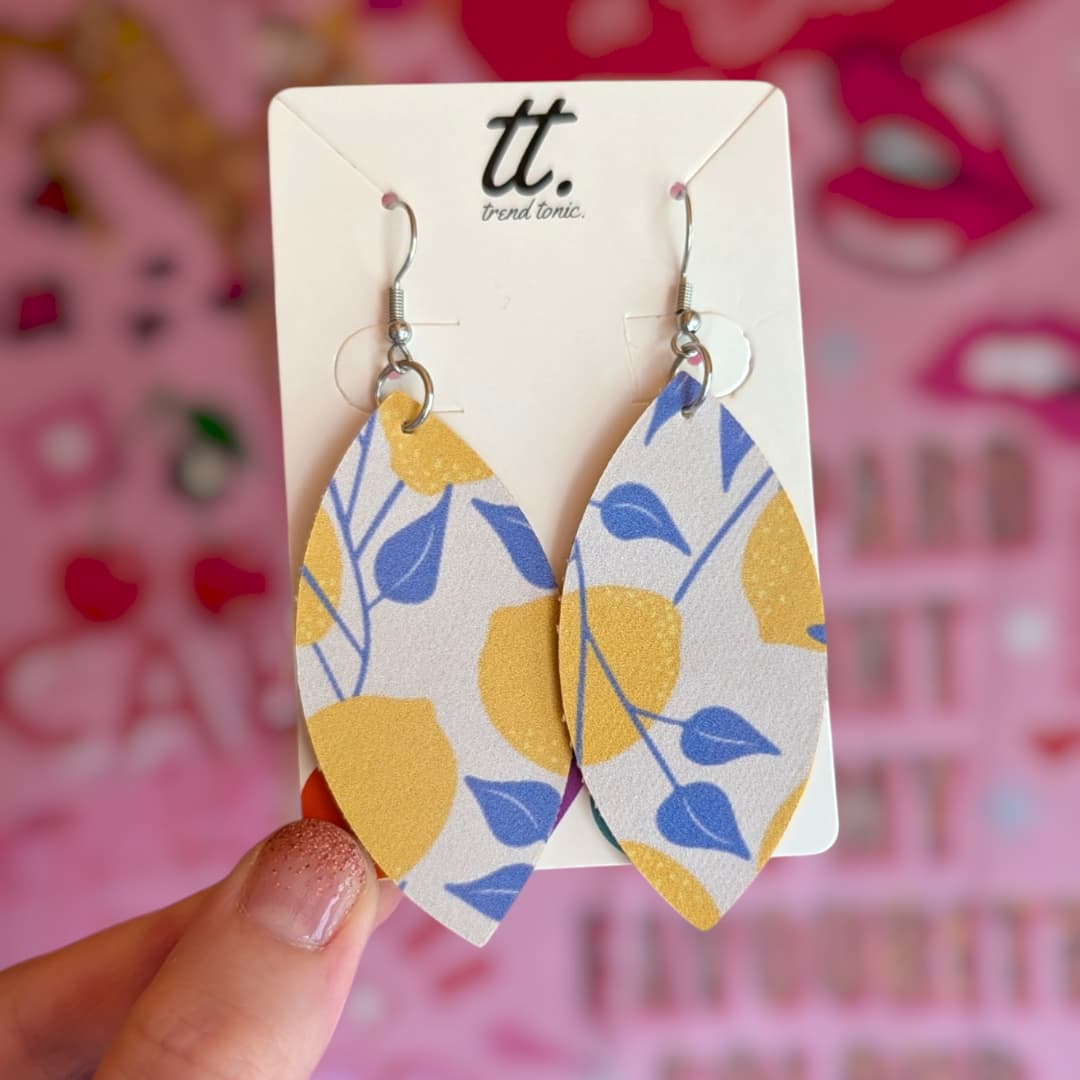 a hand holding a pair of earrings