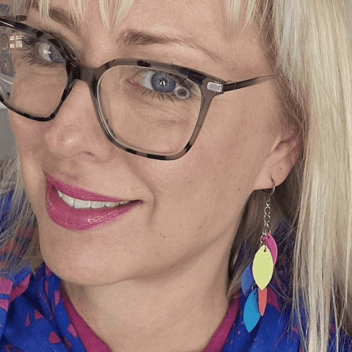 a woman wearing glasses and a blue shirt