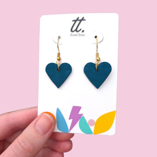 a hand holding a pair of earrings