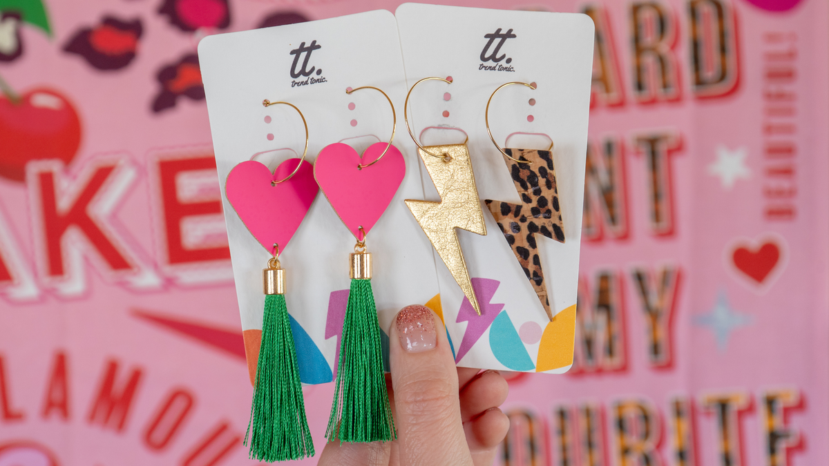 a hand holding a pair of earrings