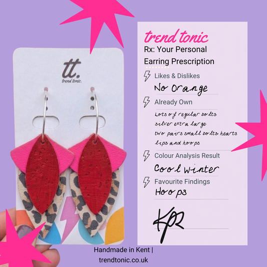 a hand holding a pair of earrings