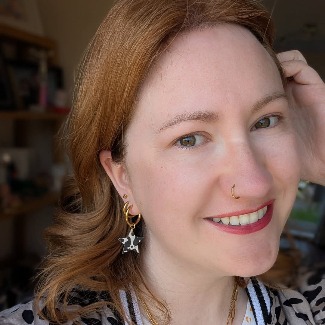 a woman with red hair and a nose ring