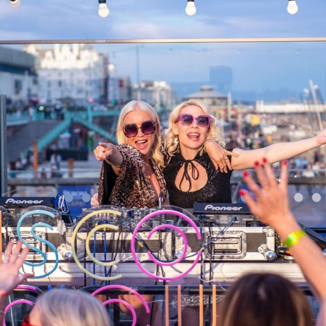 two women in sunglasses at a dj booth