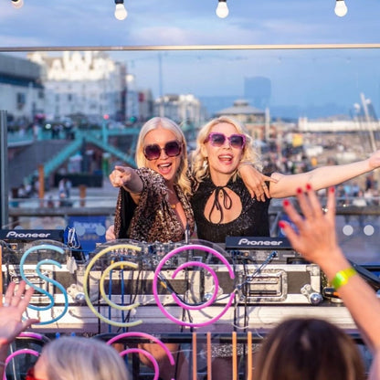 two women in sunglasses at a dj booth