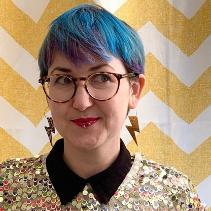 a woman with blue hair and glasses