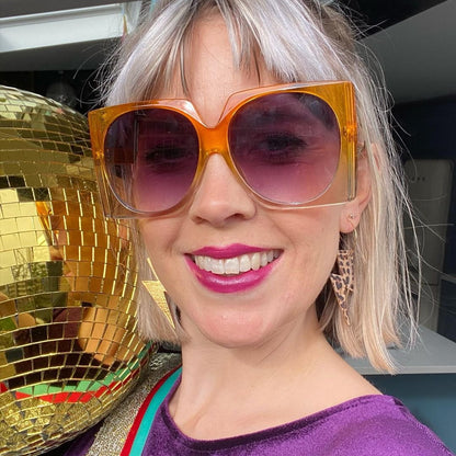 a woman wearing sunglasses and smiling