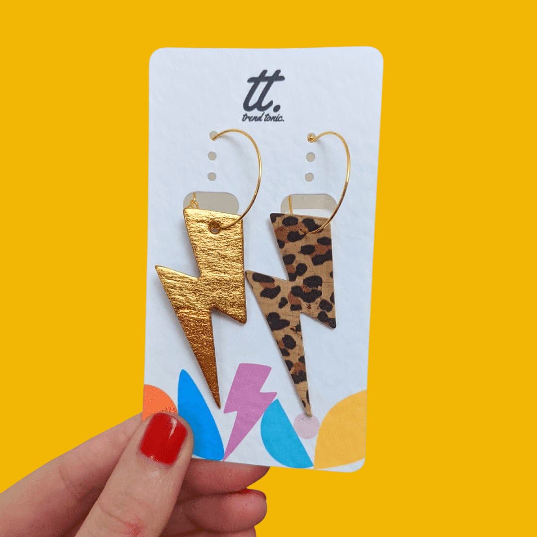 a hand holding a card with earrings