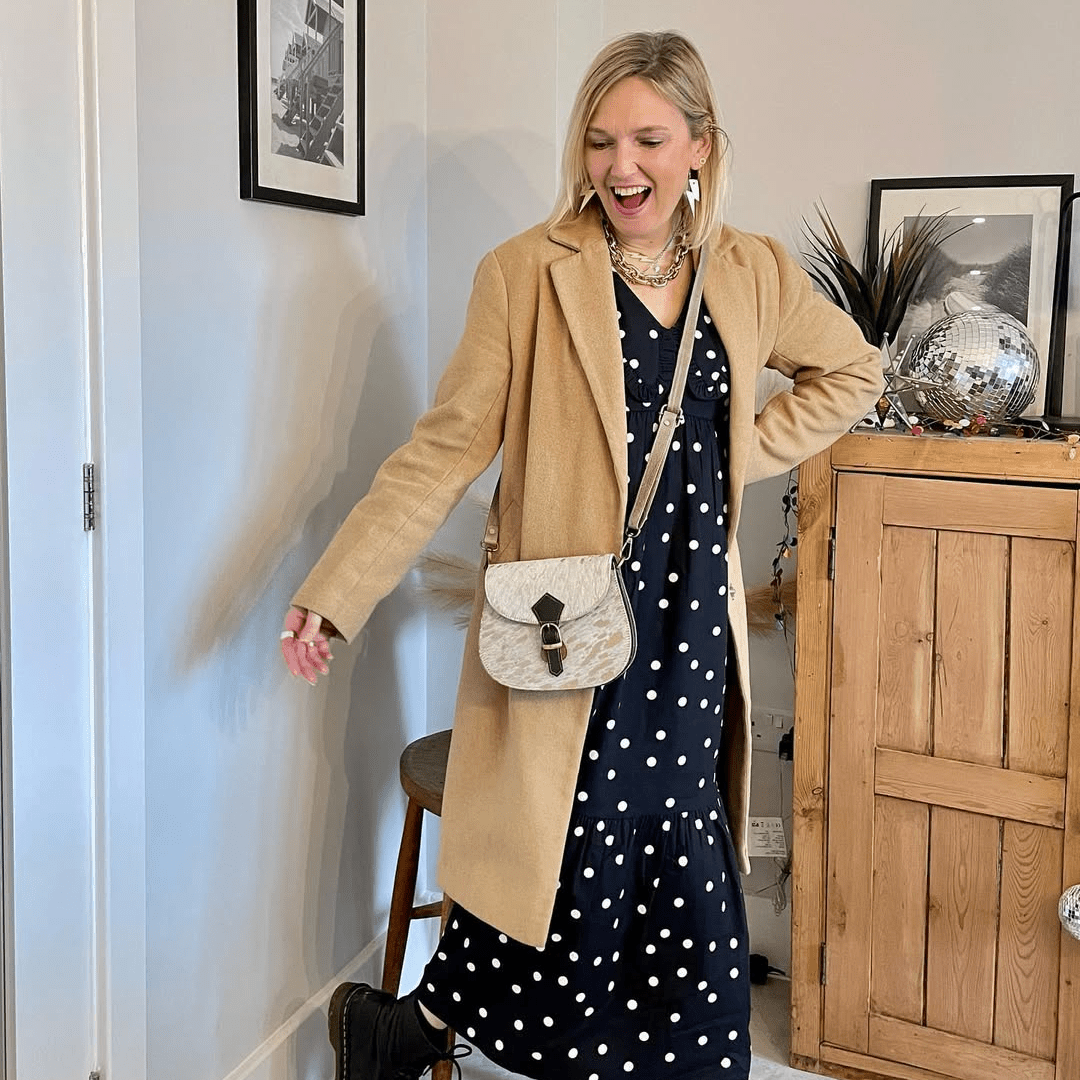 a woman in a dress and a tan coat