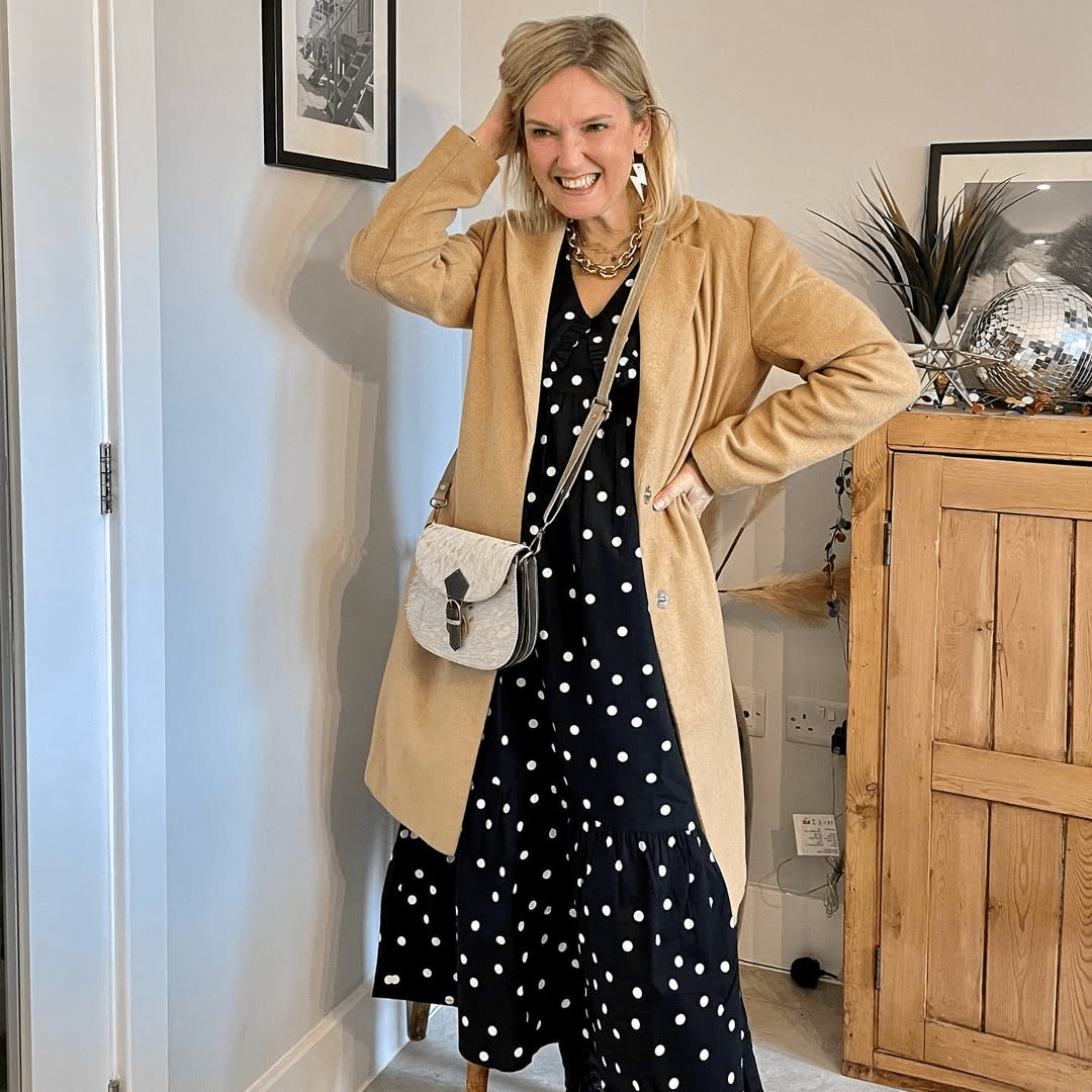 a woman in a dress and a tan coat