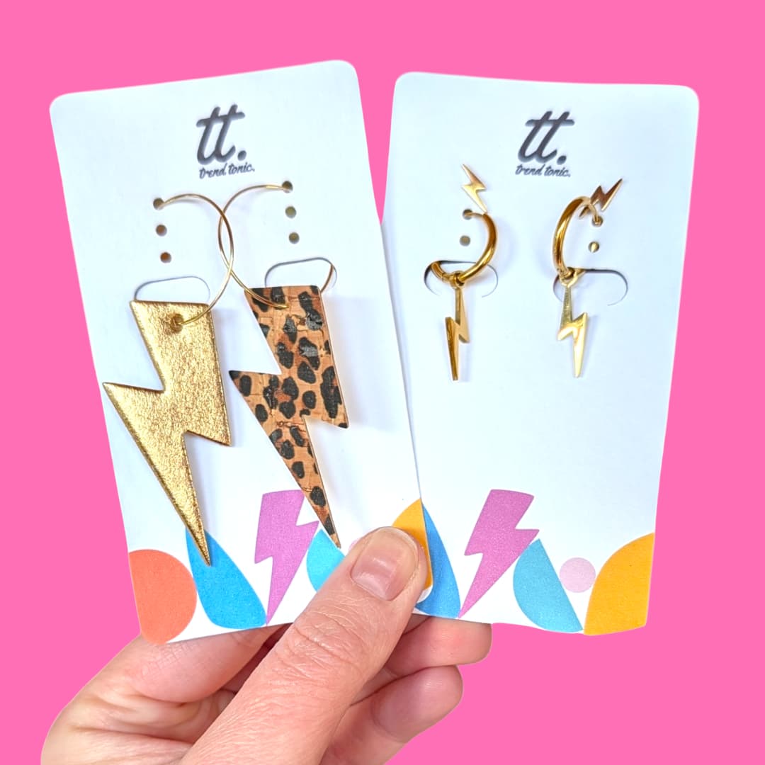 a hand holding a pair of earrings