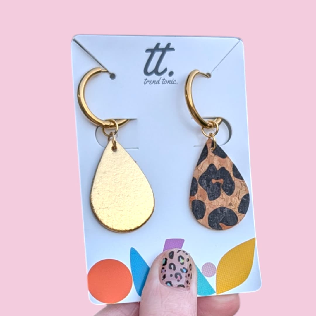 a hand holding a pair of earrings