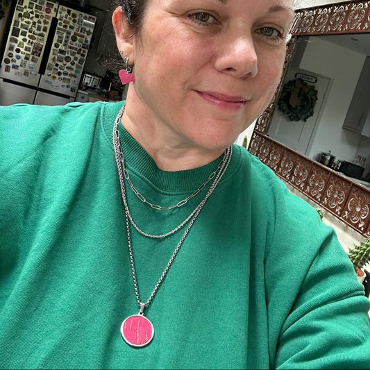a woman wearing a necklace and earrings