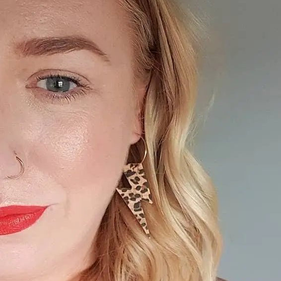 a woman with red lipstick and earrings