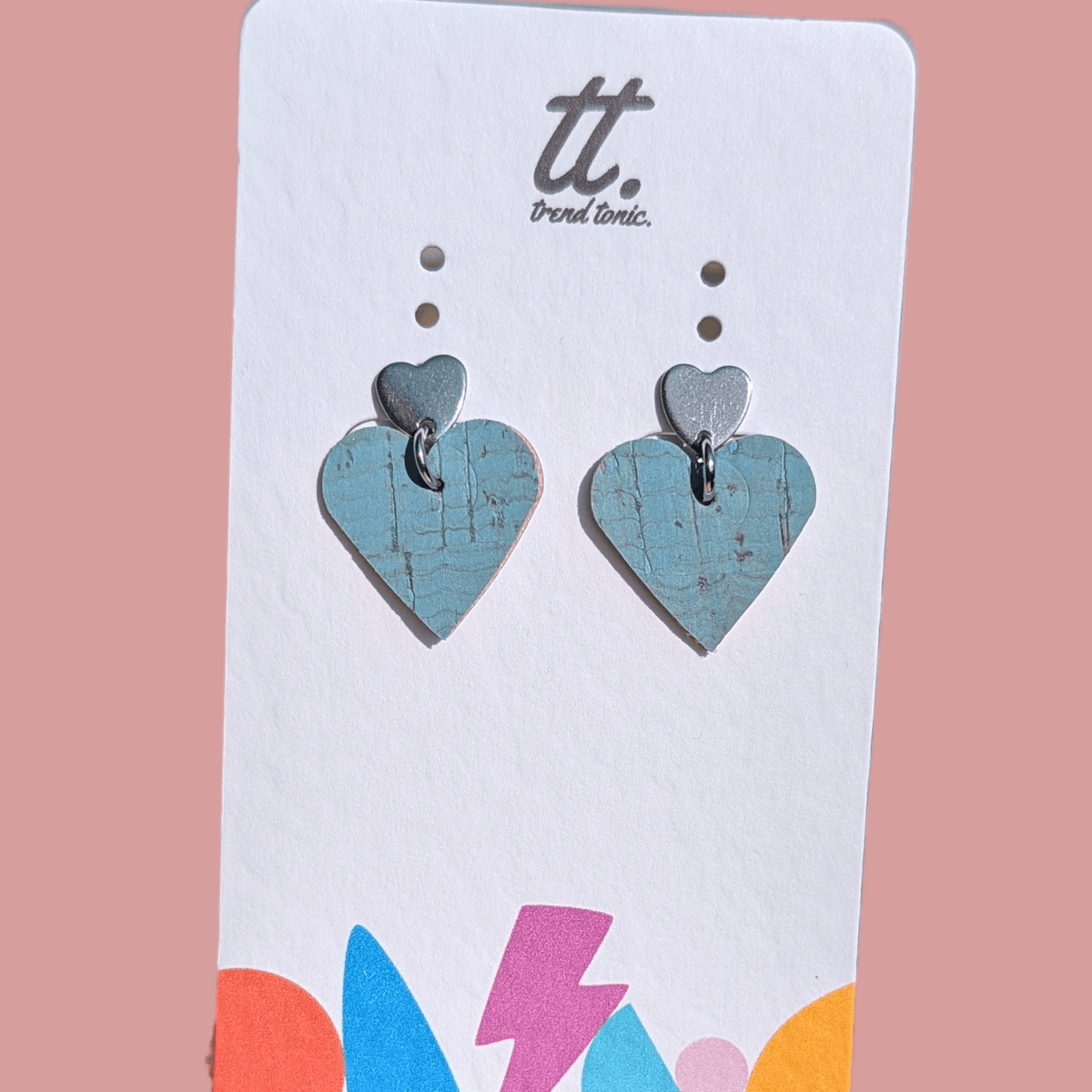 a pair of heart shaped earrings on a white card