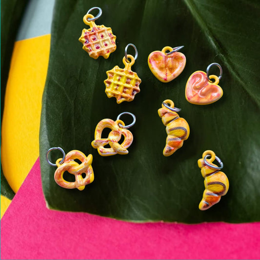 a group of colorful charms on a leaf