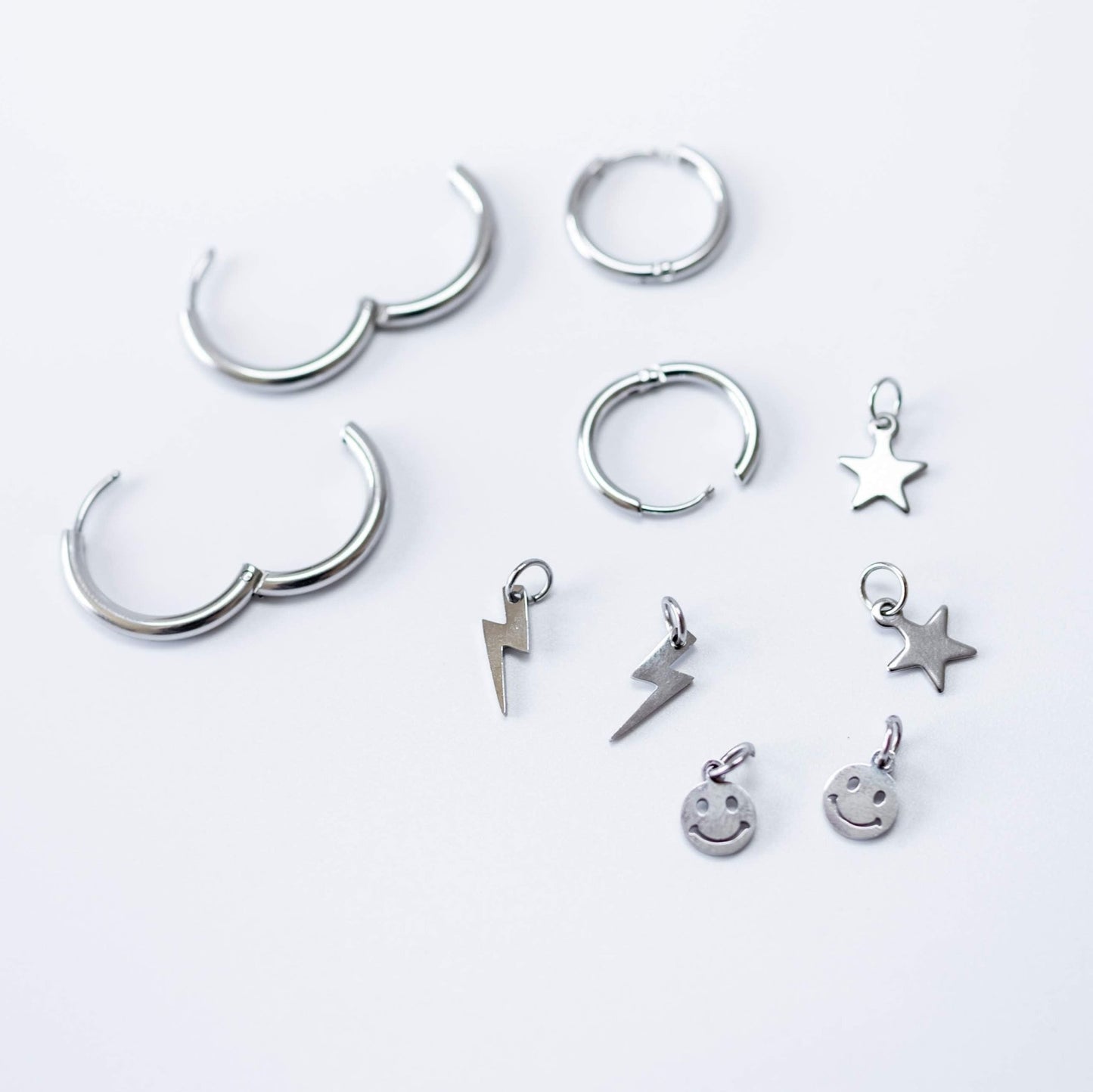 a group of silver earrings