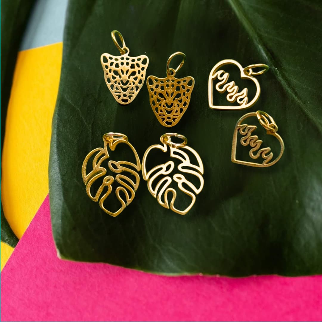 a group of gold pendants on a leaf