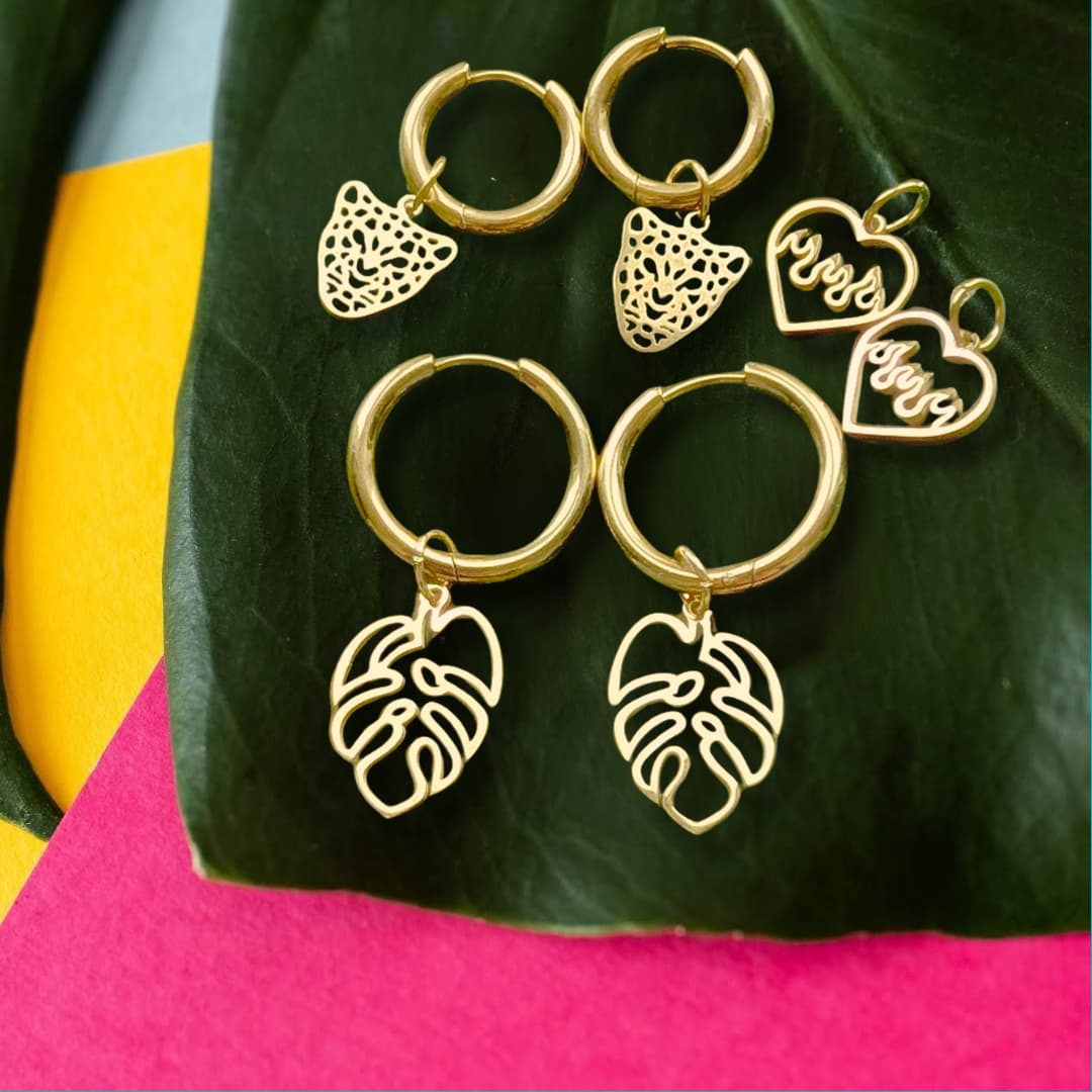 a group of gold earrings on a leaf