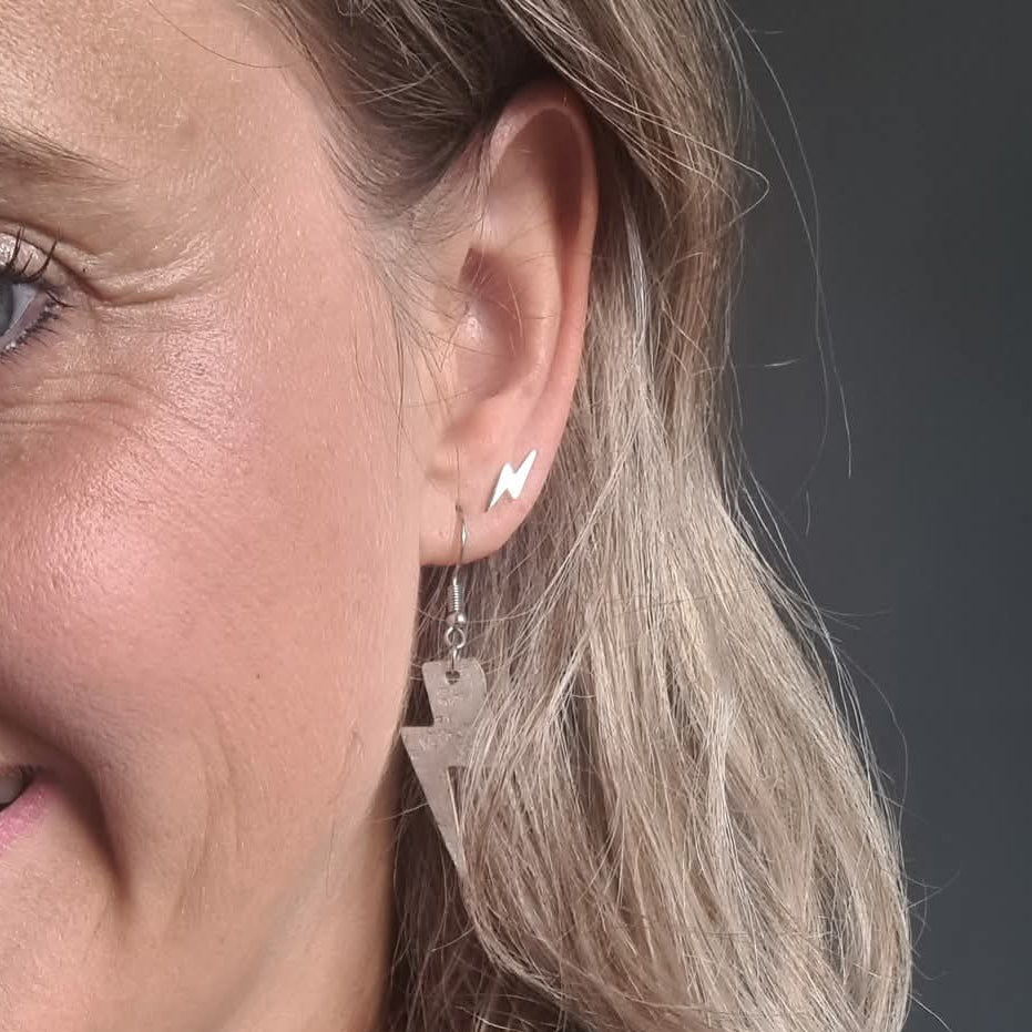 a woman's face with a lightning bolt earrings