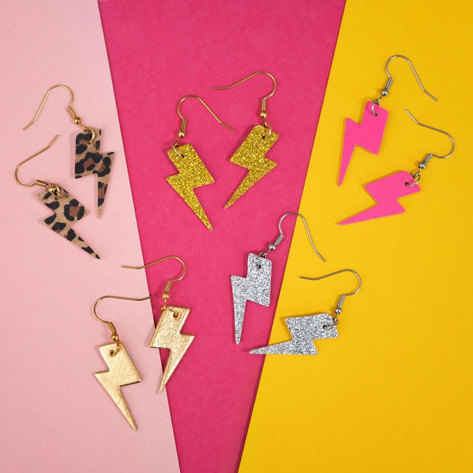 a group of earrings on a pink and yellow background