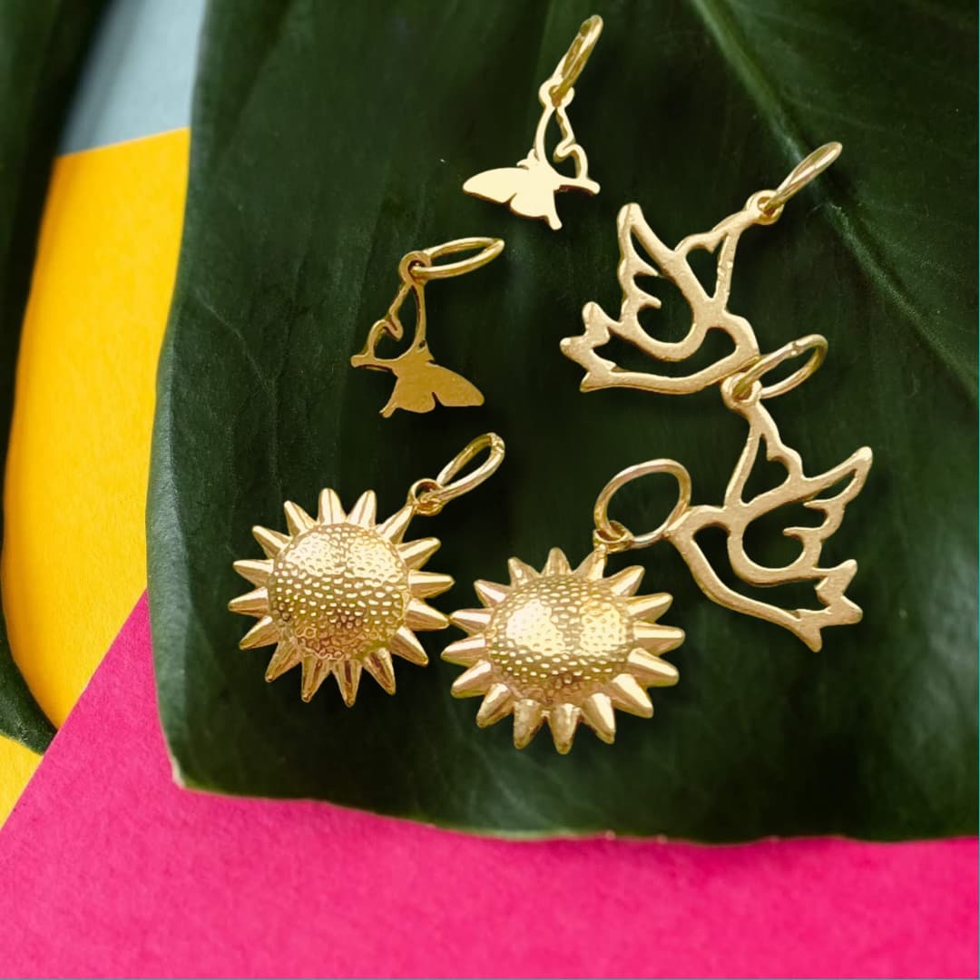 a group of gold earrings on a leaf