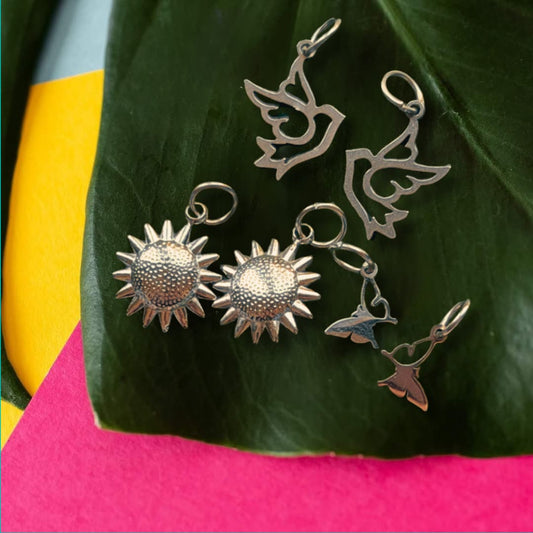 a group of silver earrings on a leaf