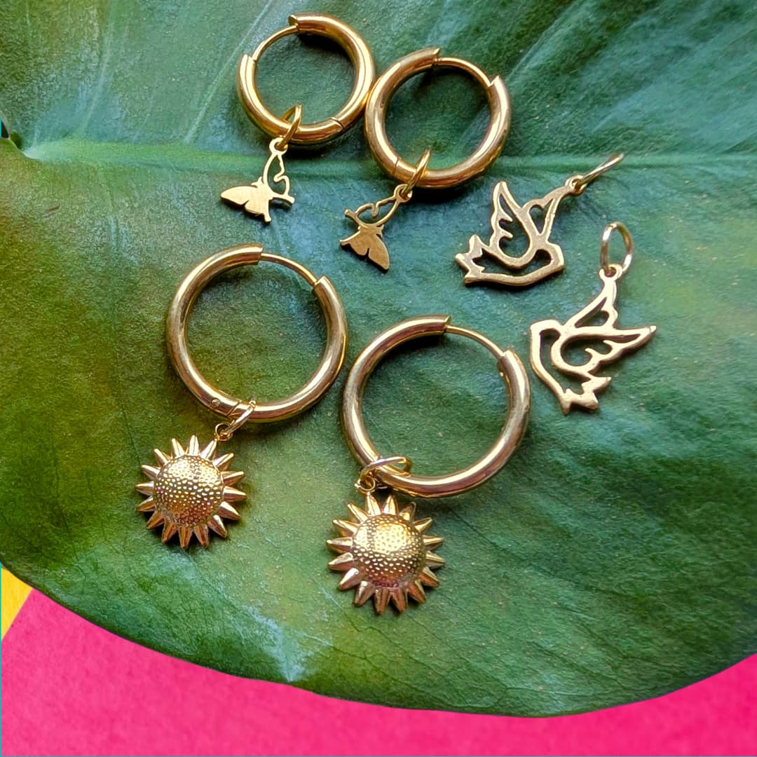 a group of gold earrings on a leaf