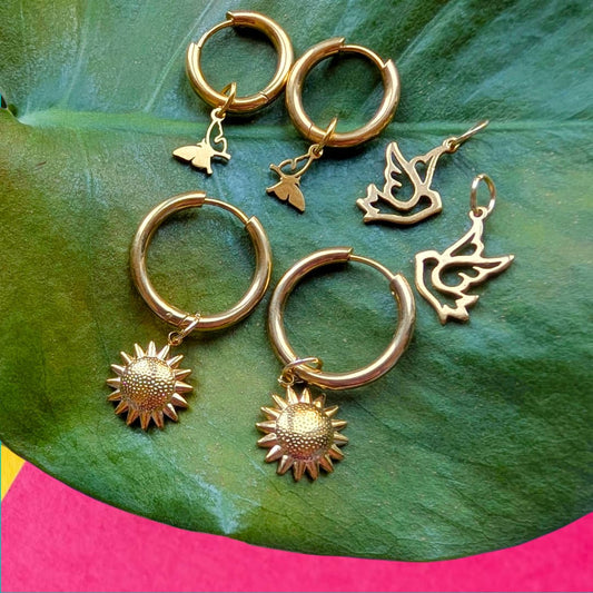 a group of gold earrings on a leaf