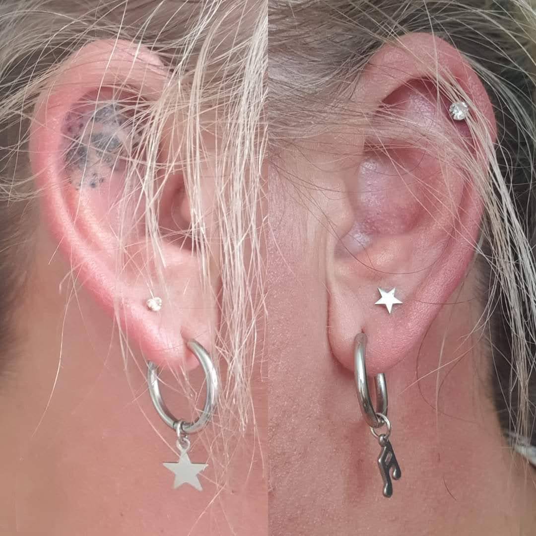 a woman's left ear with a tattoo and a star earrings