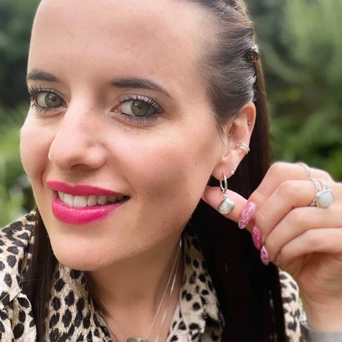 a woman with pink lipstick and earrings