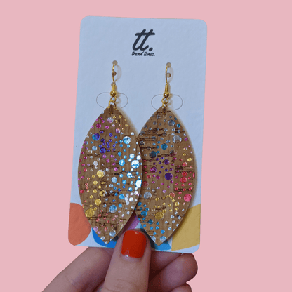 a hand holding a pair of earrings