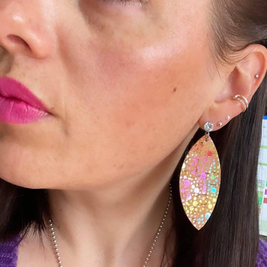 a woman with pink lipstick and earrings