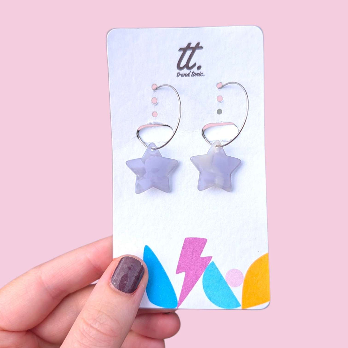 a hand holding a card with earrings