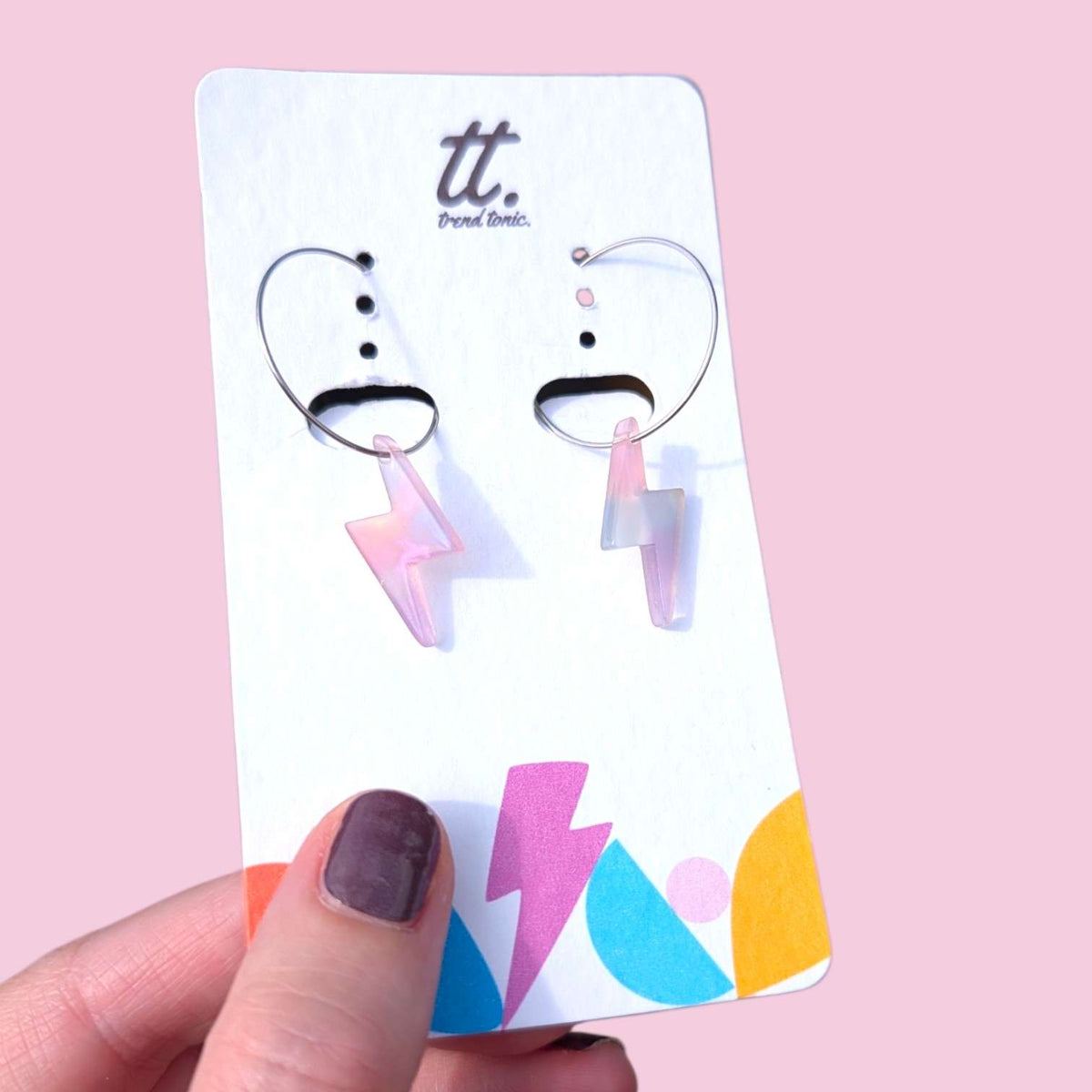 a hand holding a pair of earrings